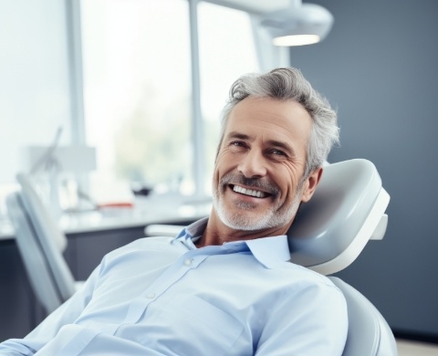 Older man smiling in dental chair