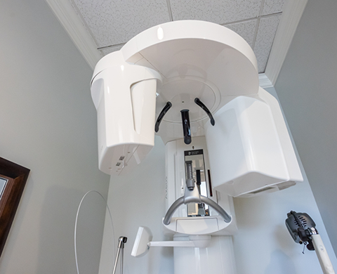 Cone beam scanner standing against white wall of dental office