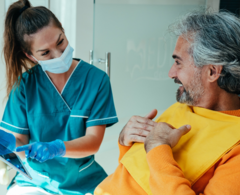 Dental team member showing a tablet to a patient