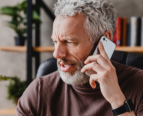 Man looking worried while talking on phone