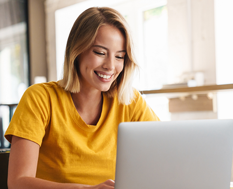 Smiling woman typing on a laptop