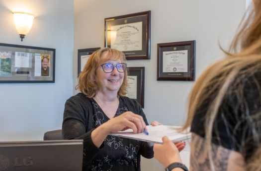 Dental team member handing a clipboard to a patient