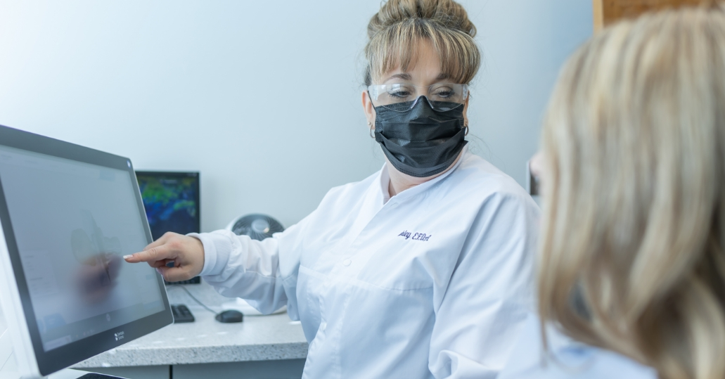 Eugene dental team member showing a patient a computer monitor