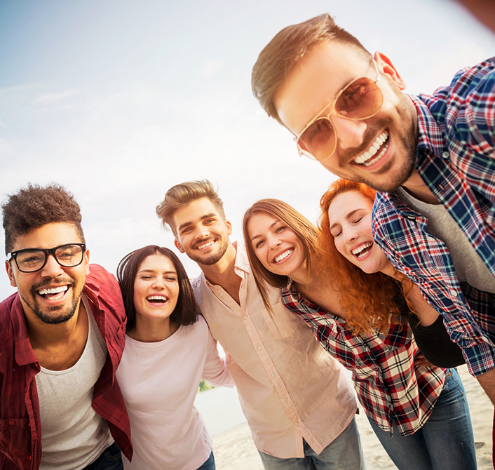 Group of adults smiling outdoors after replacing missing teeth in Eugene