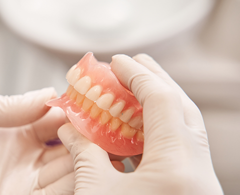 Dentist holding a set of full dentures