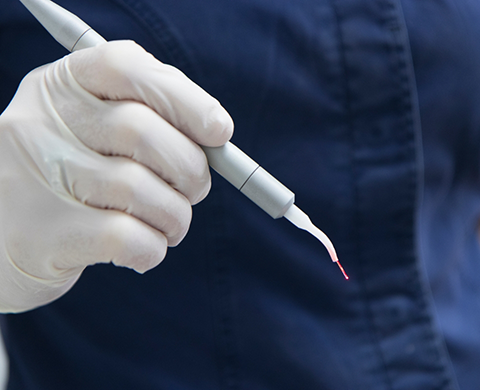 Dentist holding a laser pen