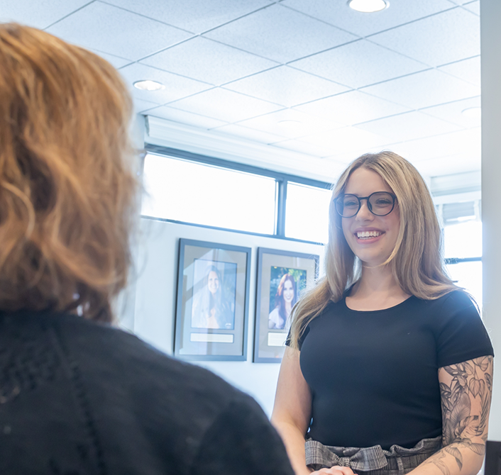 Woman smiling at dental team member during preventive dentistry checkup