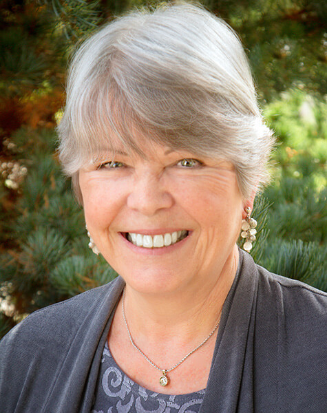 Senior woman in gray cardigan smiling