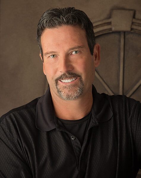 Man in collared black shirt smiling