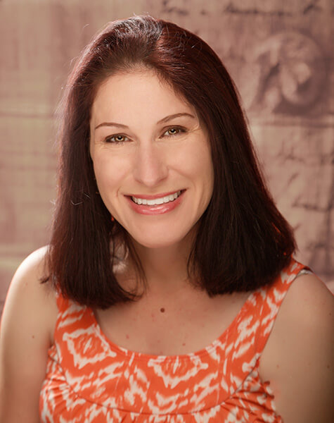 Smiling woman in orange and white top