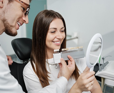 Dental assistant smiling while handing patient form